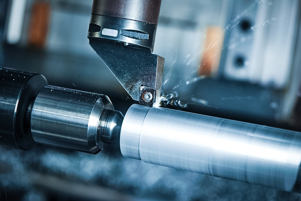 metalworking  industry: cutting steel metal shaft processing on lathe machine in workshop. Selective focus on tool